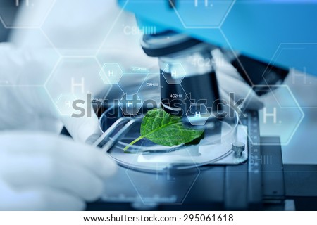 science, chemistry, biology and people concept - close up of scientist hand with microscope and green leaf making research in clinical laboratory over hydrogen chemical formula
