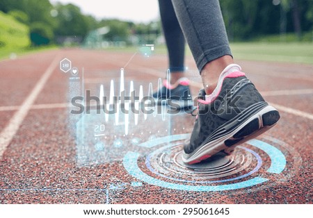 fitness, sport, training, people and healthy lifestyle concept - close up of woman feet running on track with futuristic holograms from back