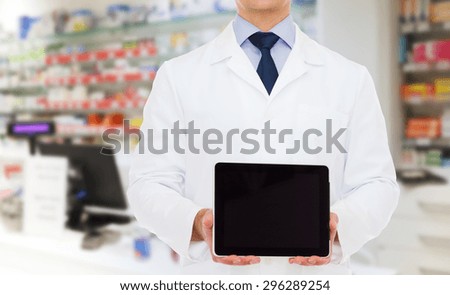 medicine, technology, advertisement, pharmacy and healthcare concept - smiling male doctor with tablet pc computer over drugstore background