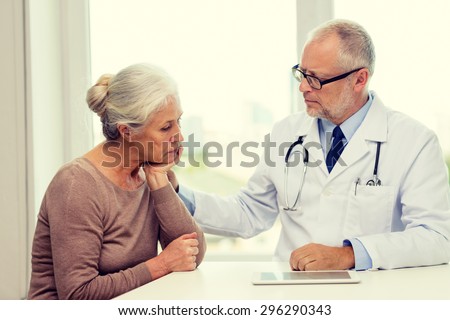 medicine, age, health care and people concept - senior woman and doctor with tablet pc computer meeting in medical office