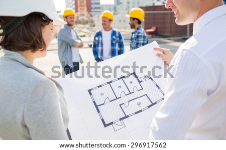 construction, architecture, business, teamwork and people concept - close up of architects with blueprint at building site