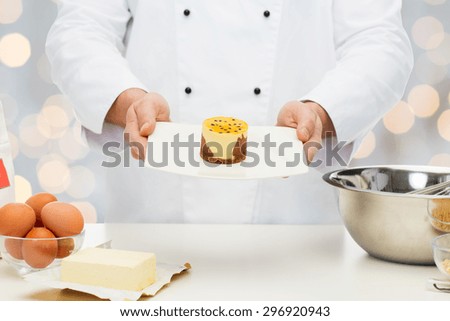 cooking, profession, haute cuisine, food and people concept - close up of male chef cook baking dessert over holidays lights background