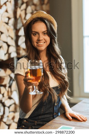 people, drinks, alcohol and leisure concept - happy young redhead woman drinking water at bar or pub