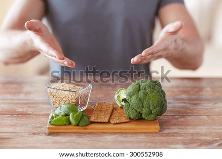healthy eating, diet and people concept - close up of male hands showing food rich in fiber