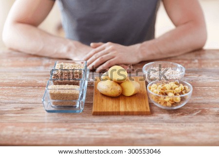 healthy eating, diet and people concept - close up of male hands with carbohydrate food on table