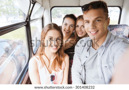 friendship, travel, vacation, summer and people concept - group of happy teenage friends with smartphone traveling by bus