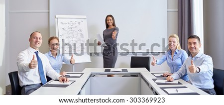 business, people and teamwork concept - group of smiling businesspeople meeting and showing thumbs up in office