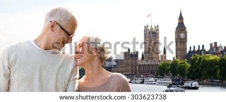 family, age, tourism, travel and people concept - happy senior couple over houses of parliament and big ben clock tower in london