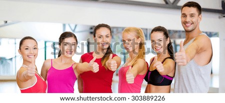 fitness, sport, training, gym and lifestyle concept - group of happy people in the gym showing thumbs up