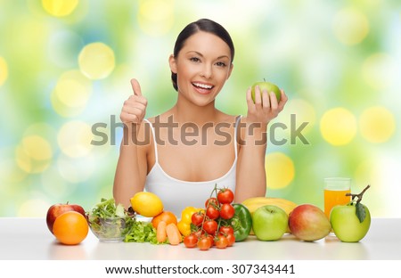 people, diet, gesture and vegetarian concept- happy asian woman with healthy food showing thumbs up over green lights background