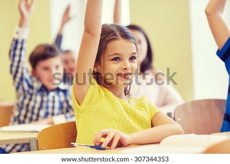 education, elementary school, learning and people concept - group of smiling school kids sitting in classroom