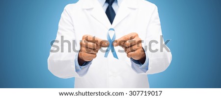 healthcare, profession, people and medicine concept - close up of male doctor hands holding sky blue prostate cancer awareness ribbon