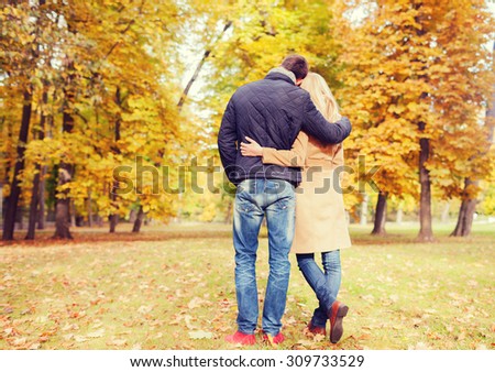 love, relationship, family and people concept - couple hugging in autumn park from back