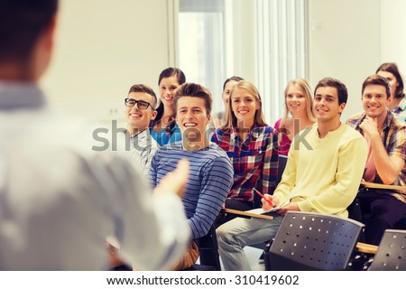 education, high school, teamwork and people concept - group of smiling students with notebooks and teacher in classroom