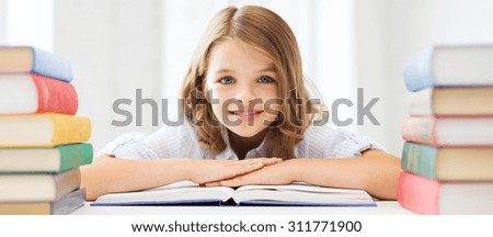 education and school concept - smiling little student girl with many books at school