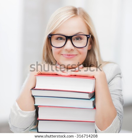 picture of smiling student with stack of books
