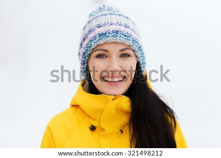 winter, leisure, clothing and people concept - happy young woman in winter clothes outdoors