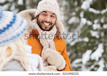 holidays, christmas, season and people concept - happy friends or couple in winter forest