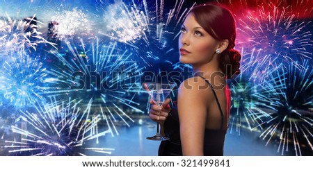 party, drinks, holidays, luxury and celebration concept - smiling woman in evening dress holding cocktail over nigh city and firework background