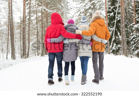 love, relationship, season, friendship and people concept - group of happy men and women walking in winter forest