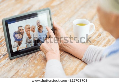 technology, age, memories and people concept - happy senior woman with tablet pc computer viewing family photo album at home