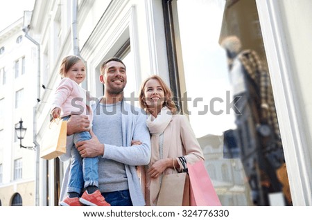 sale, consumerism and people concept - happy family with little child and shopping bags in city