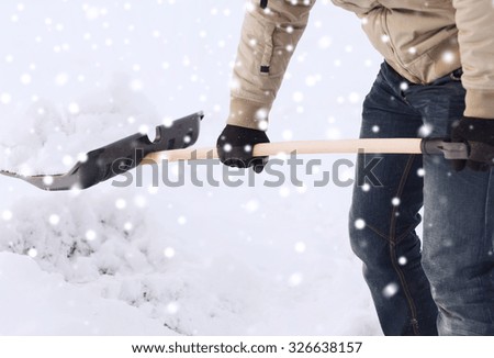 transportation, winter, people and vehicle concept - closeup of man digging snow with shovel