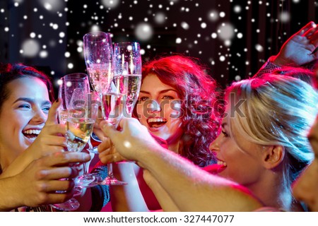 party, holidays, celebration, nightlife and people concept - smiling friends with glasses of non-alcoholic champagne in club
