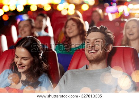 cinema, entertainment and people concept - happy friends watching comedy movie in theater