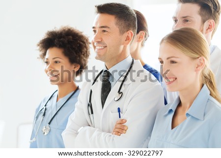hospital, profession, people and medicine concept - group of happy doctors wit stethoscopes or mentor with interns at hospital