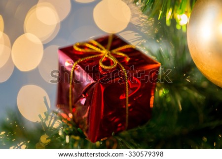holidays, new year, decor and celebration concept - close up of red gift box decoration on christmas tree
