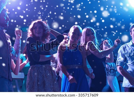 new year party, holidays, celebration, nightlife and people concept - group of happy friends dancing in night club and snow effect