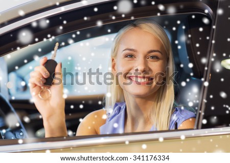 auto business, car sale, consumerism and people concept - happy woman taking car key from dealer in auto show or salon over snow effect