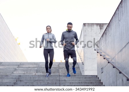 fitness, sport, exercising, people and lifestyle concept - couple walking downstairs on stadium