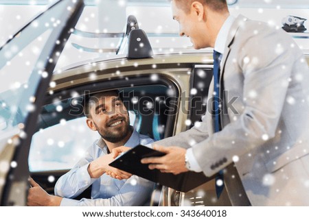 auto business, car sale, consumerism, gesture and people concept - happy man with car dealer making deal and shaking hands in auto show or salon over snow effect