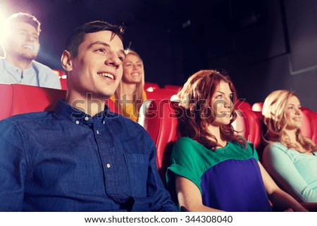 cinema, entertainment and people concept - happy friends watching movie in theater