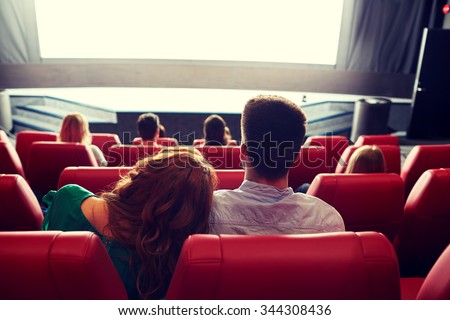 cinema, entertainment, leisure and people concept - happy, couple watching movie in theater from back