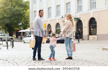 sale, consumerism and people concept - happy family with little child and shopping bags in city