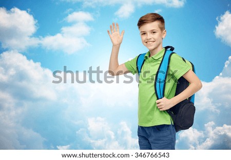 childhood, school, education, greeting gesture and people concept - happy smiling student boy with school bag waving hand over blue sky and clouds background