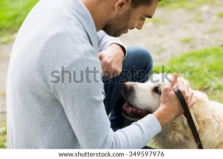 family, pet, animal and people concept - close up of happy man with labrador retriever dog on walk