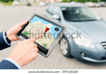close up of hands with gps on tablet pc and car
