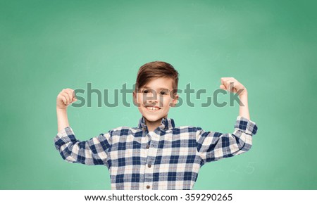 happy boy in checkered shirt showing strong fists