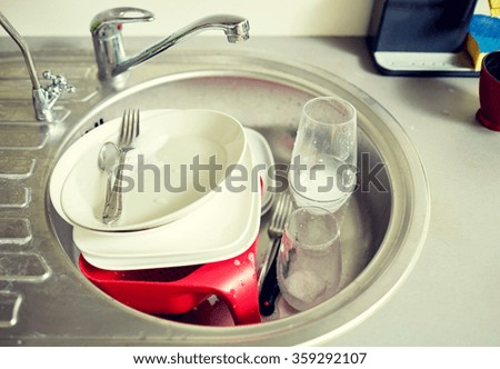 close up of dirty dishes washing in kitchen sink