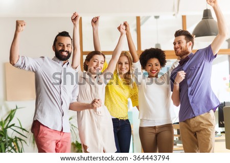 happy creative team celebrating victory in office