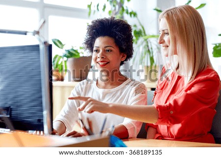 happy women or students with computer in office