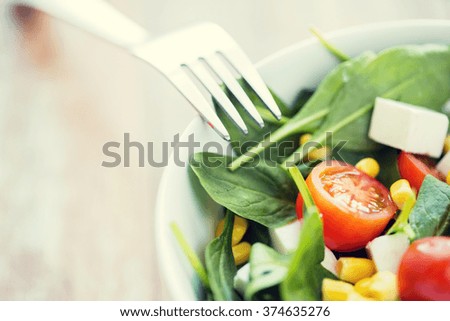 healthy eating, dieting, vegetarian kitchen and cooking concept - close up of vegetable salad bowl and fork at home
