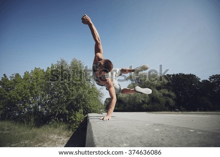 fitness, sport, parkour and people concept - young man jumping in summer park