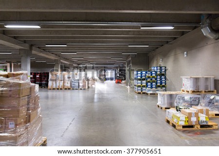 logistic, storage, loading, shipment and equipment concept - forklift loader and boxes at warehouse