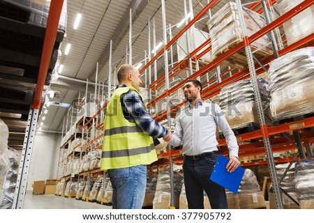 wholesale, logistic, people and export concept - manual worker and businessmen with clipboard shaking hands and making deal at warehouse