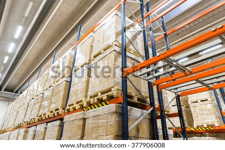 logistic, storage, shipment, industry and manufacturing concept - cargo boxes storing at warehouse shelves